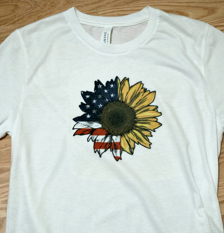 White t shirt with half American flag and half sunflower sublimation on front.